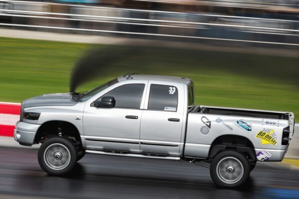 Une voiture en course avec de la fumée pour le blog: Comment réduire la consommation d’essence