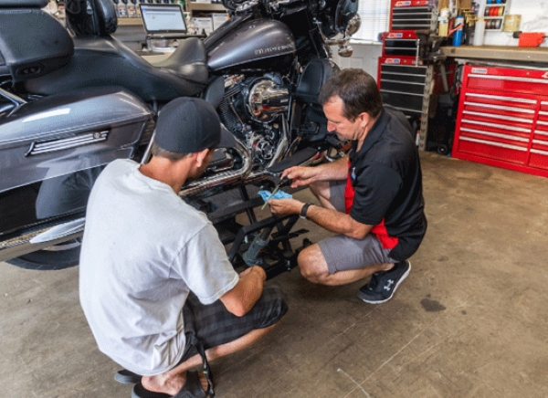 AMSOIL - entretien de la moto dans l'atelier avec 2 mécaniciens